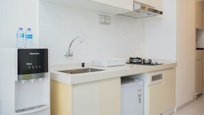 Een moderne keuken met een ingebouwd waterdispenser, een spoelbak en een compacte koelkast.