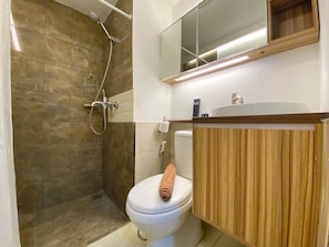 Moderni kylpyhuone, jossa on suihku, wc ja pesuallas.