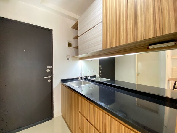 Studio | Privékeuken | Een koelkast, een kookplaat, een waterkoker, kookgerei, borden en bestek