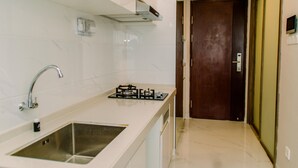 A modern kitchen with a stainless steel sink, a gas stove, and a white countertop.