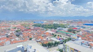 Un paisaje urbano con una mezcla de edificios residenciales y comerciales, incluyendo una gran estructura azul y un edificio verde con señalización.