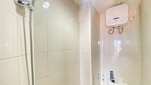 Un baño moderno con ducha, inodoro y secamanos.