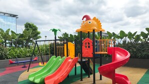 A playground with multiple slides and a climbing structure. - Cozy And Nice Studio At Sayana Bekasi Apartment (Tarumajaya)