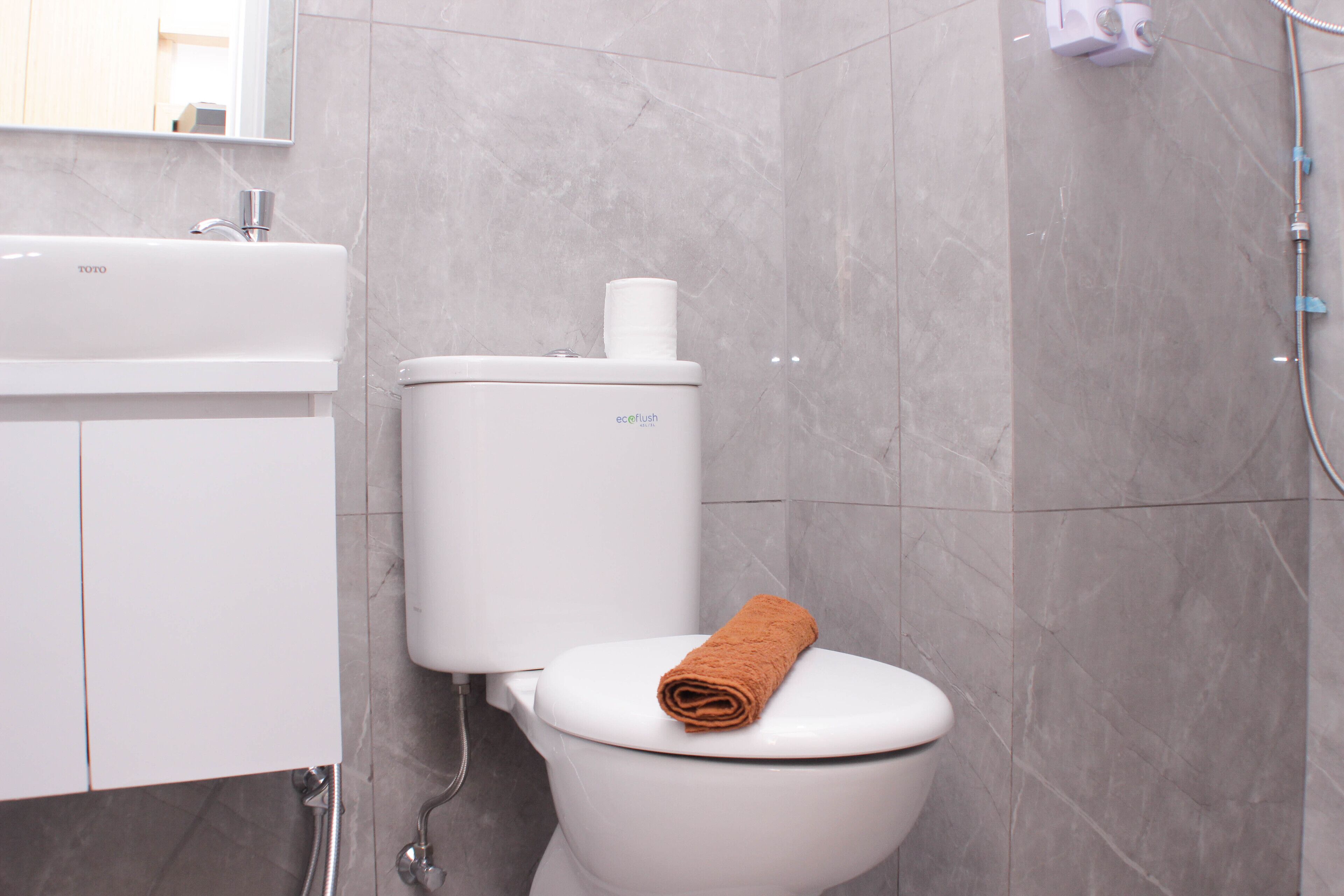 A modern bathroom with a toilet, a sink, and a shower.