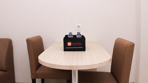 A small round table with a black tray containing two bottles and a travelio branded box. - Nice And Comfy 2Br Springlake Apartment Near Summarecon Bekasi (Bekasi)