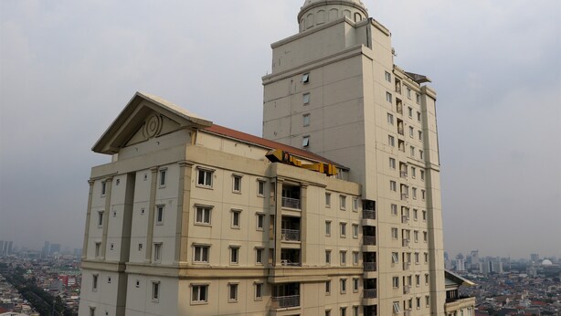 A multi-story building with a prominent dome on top, featuring balconies and a mix of window sizes. - Spacious And Elegant 3Br At Grand Palace Kemayoran Apartment (Jakarta)