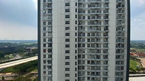 A high-rise building with multiple balconies, a view of a highway, and distant cityscape. - Elegant And Restful Studio At Casa De Parco Apartment (South Tangerang)