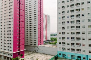 A high-rise building with multiple floors, featuring a mix of white and pink facades.
