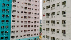 A multi-story residential building with balconies and windows. - Modern Look 2Br Green Pramuka City Apartment Near Mall (Jakarta)