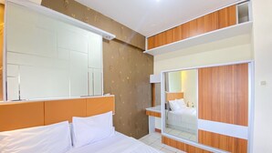 Une chambre d’hôtel avec un grand lit, une armoire, un miroir et une fenêtre.
