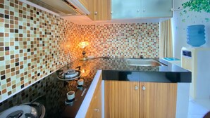 Une cuisine moderne avec un dosseret carrelé, des armoires en bois et une cuisinière à gaz.