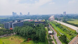 Un paisaje urbano moderno con rascacielos, una autopista y zonas verdes circundantes.