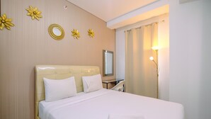 A hotel room with a large bed, a bedside table, a mirror, and a lamp. - Best View 2Br At Transpark Cibubur Apartment With Sofa Bed (Depok)