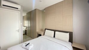 Une chambre d’hôtel moderne équipée d’un grand lit, d’une armoire, d’un miroir et d’un appareil de climatisation.