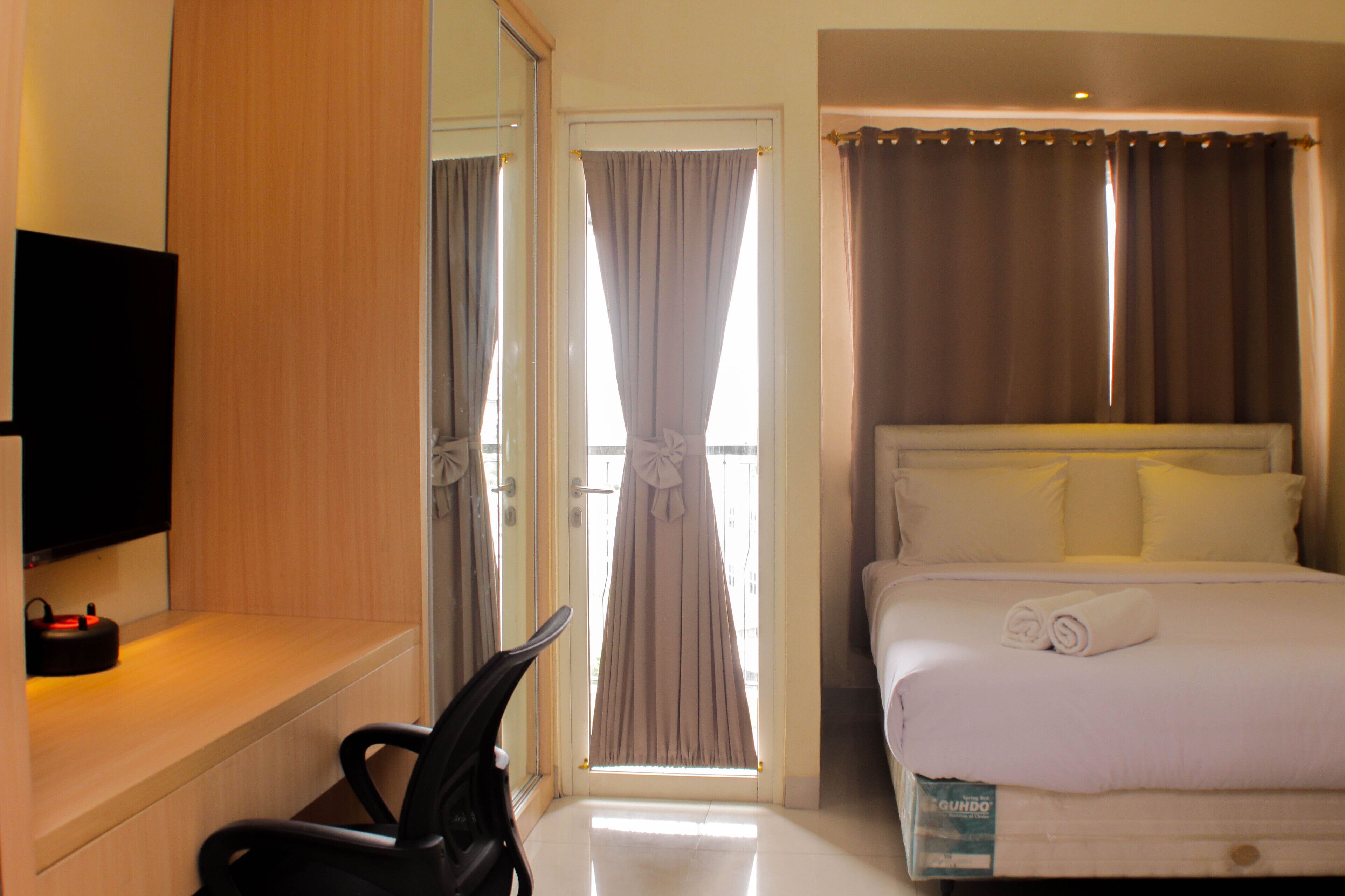 Une chambre d’hôtel avec un lit, une télévision, un bureau et une chaise.
