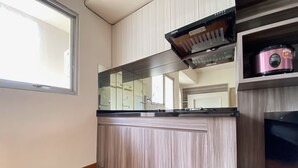 Eine Küche mit Holzarbeitsplatte, einem Einbauofen und einer Mikrowelle.