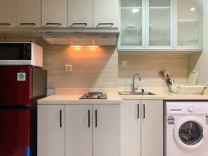 Studio | Private kitchen | Fridge, stovetop, cookware/dishes/utensils - Well Appointed And Cozy Studio At West Vista Apartment (Jakarta)