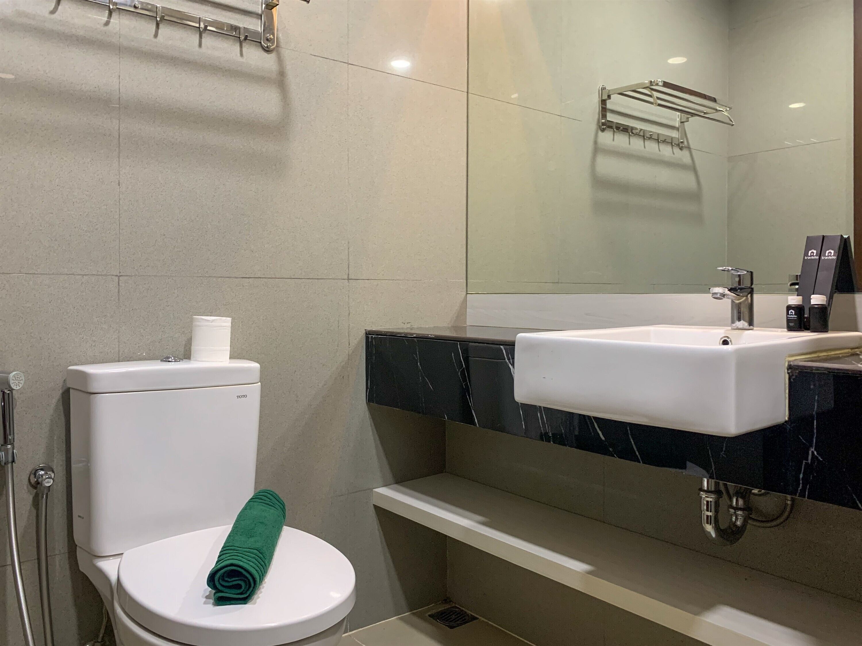 Ein Badezimmer mit Toilette, Waschbecken, Dusche und Handtuchhalter.