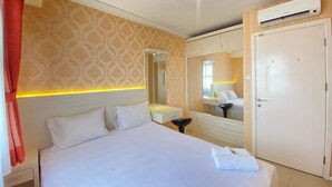 A hotel room with a large bed, a bedside table, a mirror, a wardrobe, and a ceiling light. - Classic Private 1Br Apartment At Parahyangan Residence Bandung (Bandung)