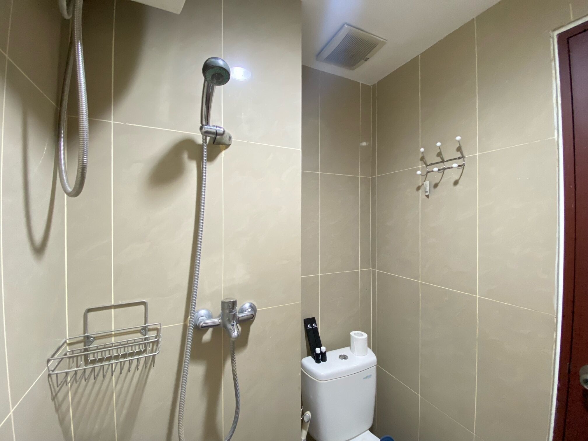 A bathroom with a shower, toilet, and towel rack.