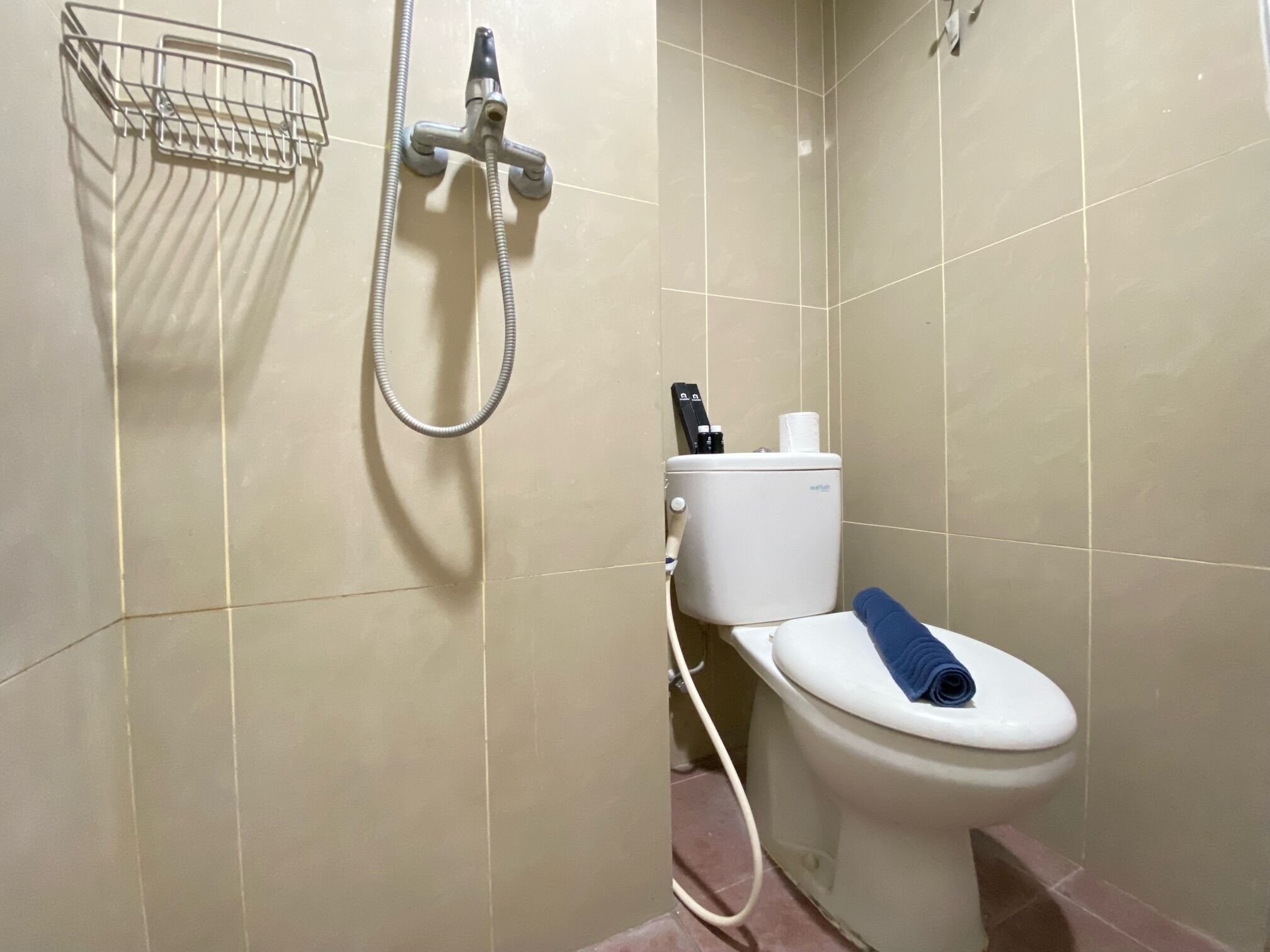 A bathroom with a toilet, a shower, and a hand dryer.