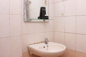 A bathroom with a white sink, a mirror, and a glass shelf with toiletries. - Homey And Comfort Living 2Br At Mediterania Palace Apartment (Jakarta)