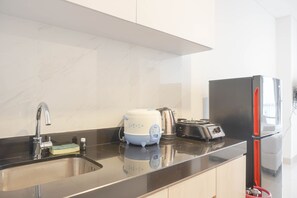 Studio | Privékeuken | Een koelkast, een kookplaat, kookgerei, borden en bestek