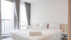 Une chambre d’hôtel moderne avec un grand lit, une table de chevet, une commode et une vue sur la ville par la fenêtre.