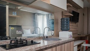 Uma cozinha compacta com bancada de granito, fogão embutido, pia e micro-ondas.