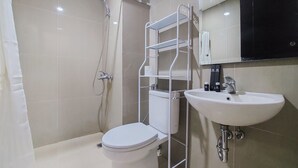 Um banheiro com vaso sanitário, pia, chuveiro e um armário.