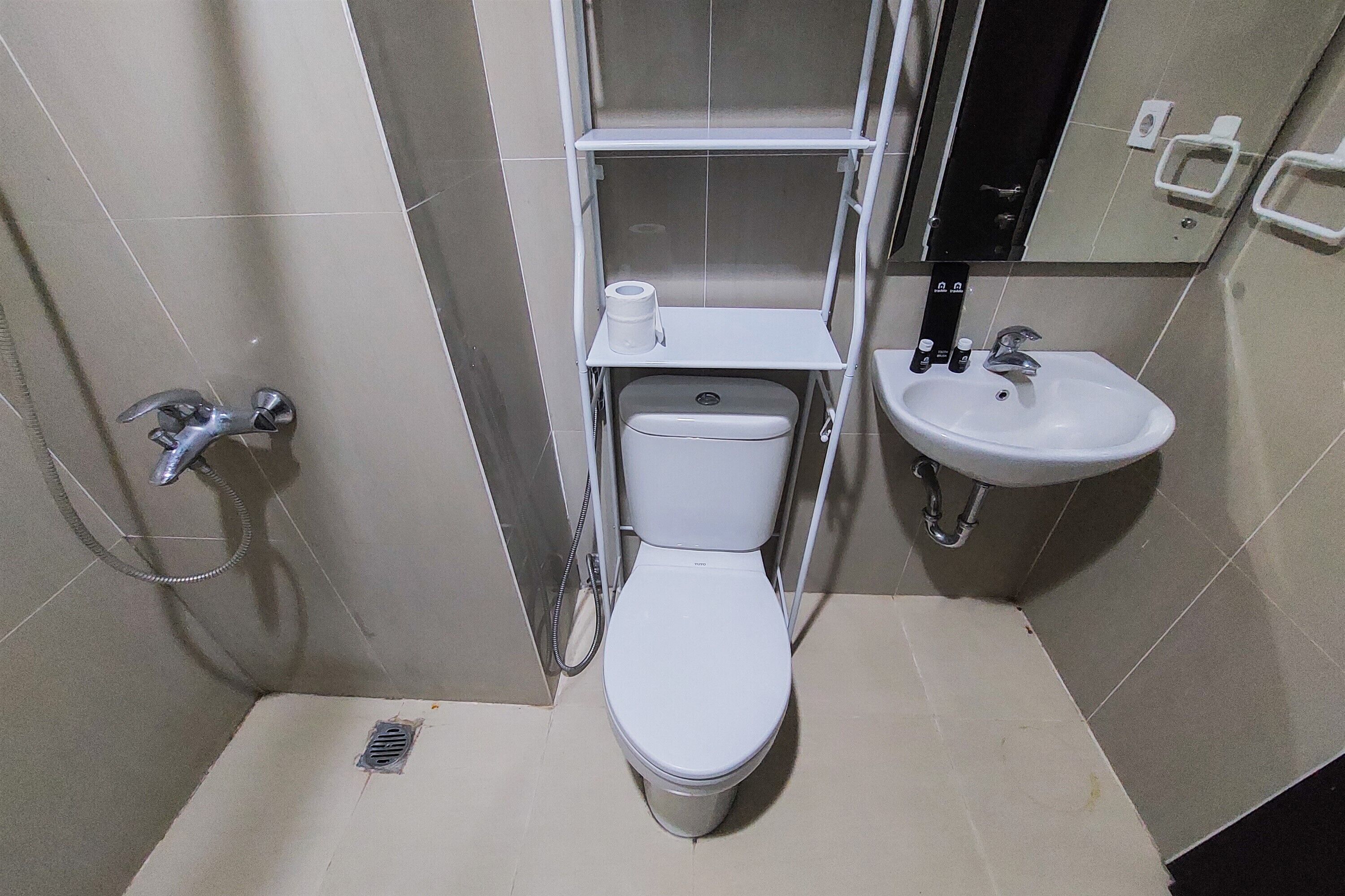 Een kleine badkamer met toilet, wastafel en douche.