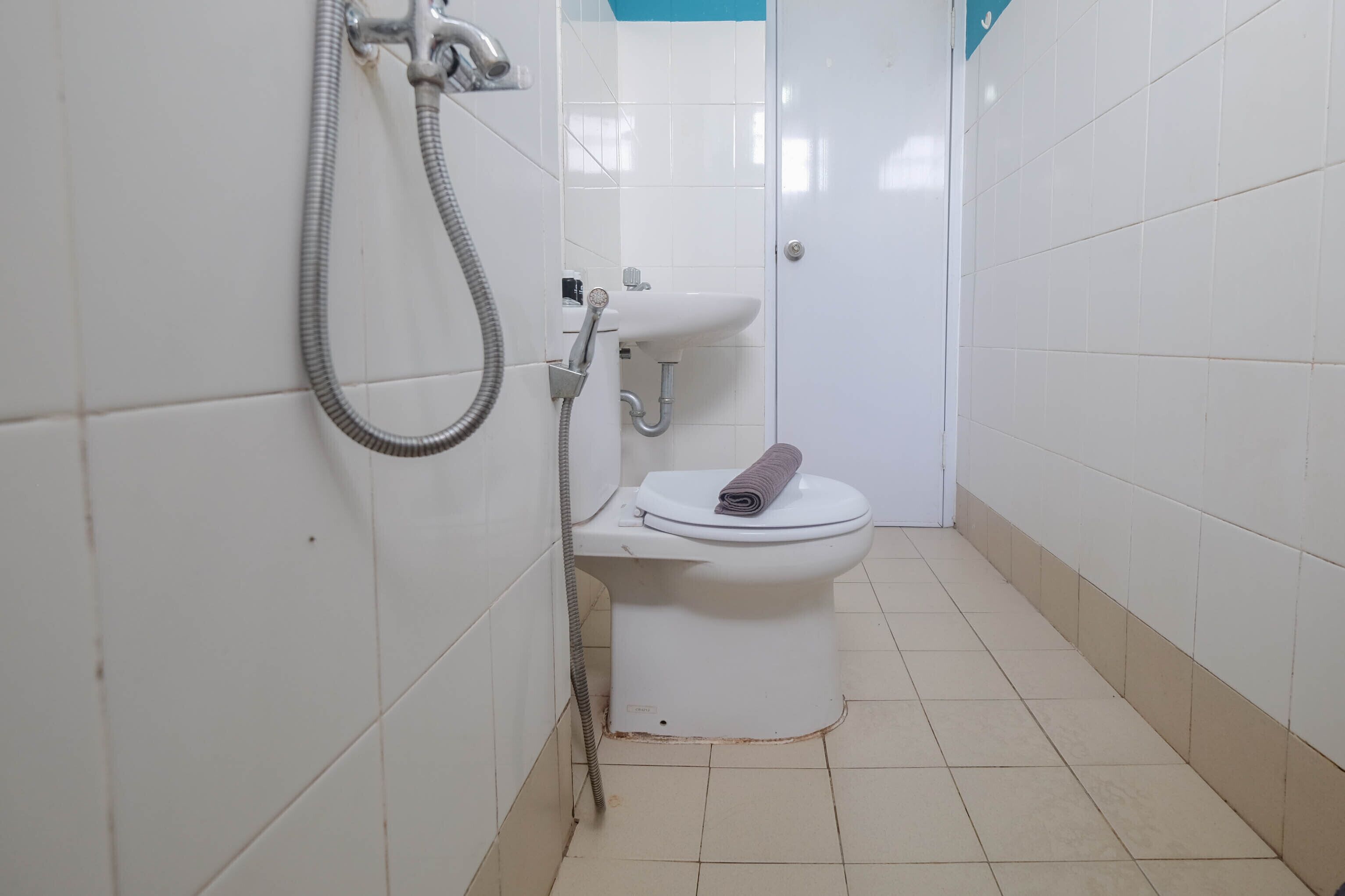 A small, compact bathroom with a toilet, a sink, and a shower.