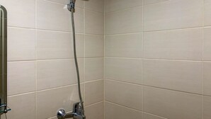A shower with a handheld showerhead and a fixed wall-mounted faucet. - Tranquil Living Studio At Belmont Residence Puri Apartment (Jakarta)