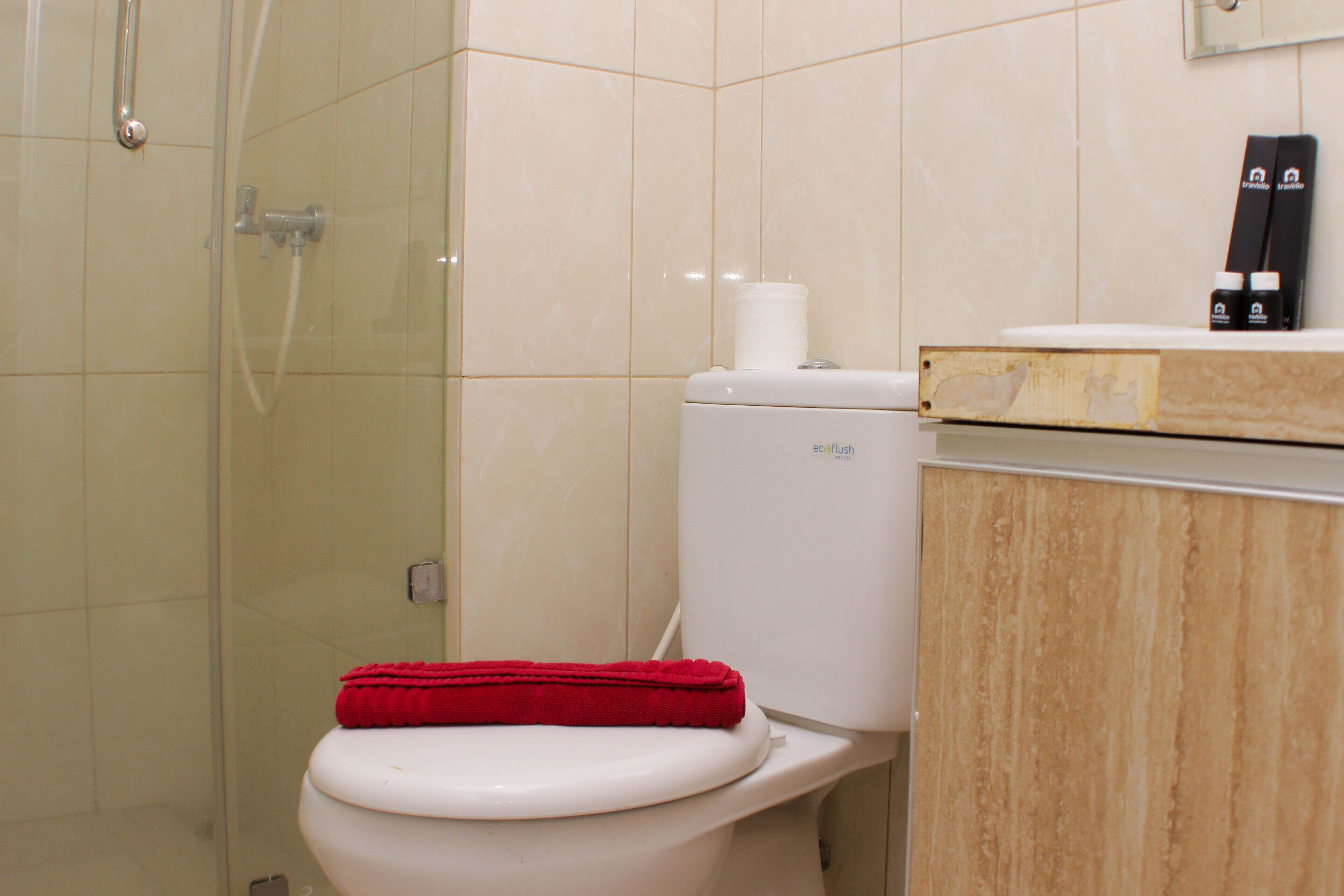 Une salle de bain équipée de toilettes, d’une douche et d’un meuble-lavabo avec un miroir.