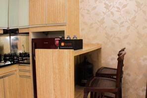 Eine Küche mit Holzausstattung, einem Gasherd, einem Kühlschrank und einem Travelio-Kühlschrank.