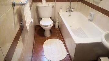 Bathtub, towels, soap, toilet paper