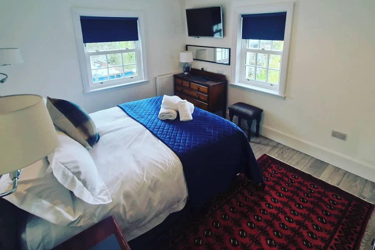 Ein Schlafzimmer mit einem Bett, einem Schminktisch, einem Spiegel und einem Fernseher.