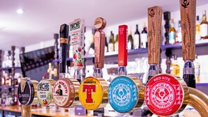 Un bar amb diverses aixetes de cervesa, incloent marques com Guinness i Tennent's.