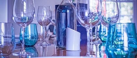 A table set with various glassware and a bottle, likely for a dining event.