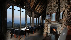 Ein gemütliches Interieur mit Steinwänden, einem Kamin und Bergblick.