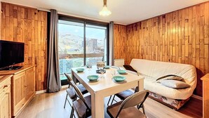 Una habitación acogedora con una mesa de comedor, sillas, un sofá y un televisor.