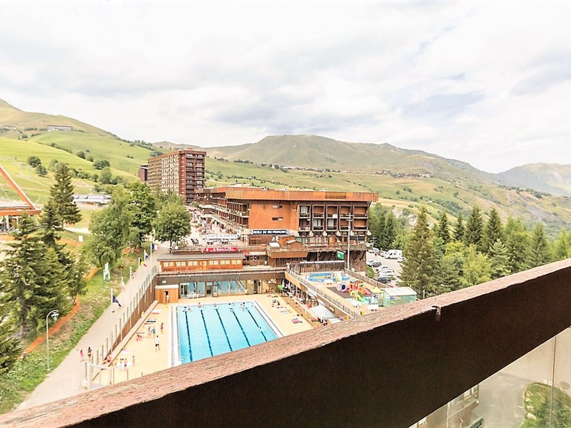 Un hôtel doté d’une piscine, de plusieurs étages et offrant une vue sur les collines environnantes.