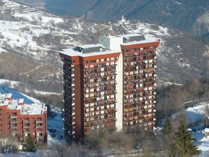 Stunning mountain views from a modern residential building with a central tower.