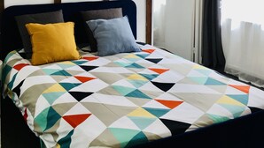 Ein Schlafzimmer mit einem Bett, einer Holzbalkendecke und einer Tür.