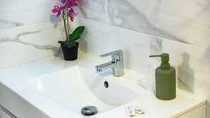 Habitación doble Deluxe | Baño | Regadera, regadera tipo lluvia, secadora de cabello, toallas 