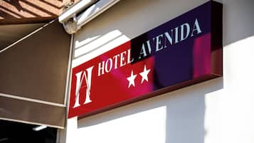 A hotel sign with the name 'HOTEL AVENIDA' and three stars.