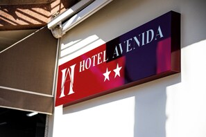 Een hotelsbord met de naam 'HOTEL AVENIDA' en drie sterren.