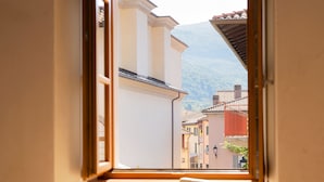 A room with a window overlooking a town and mountains. - Locanda Alberti (Mandello del Lario)