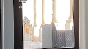 Une porte donnant sur des colonnes antiques et sur la façade d’un bâtiment.