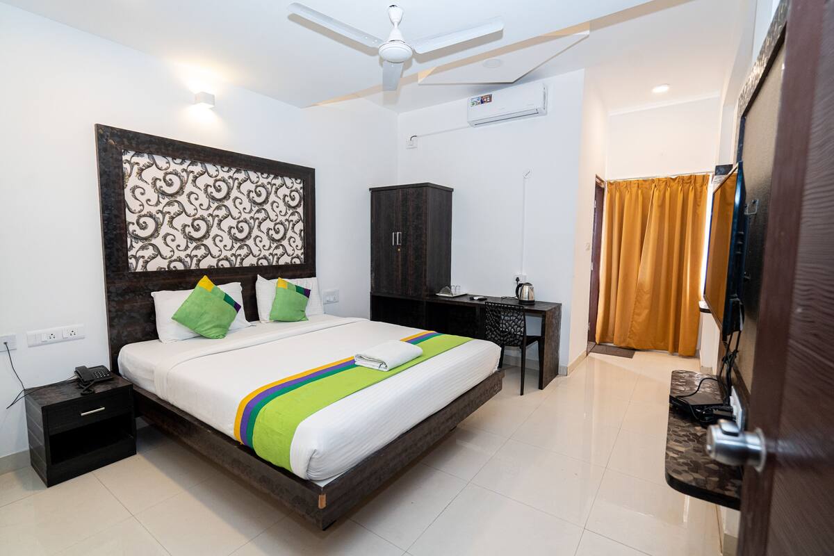 Une chambre d’hôtel équipée d’un lit, d’un bureau, d’une armoire, d’un ventilateur de plafond et d’un appareil de climatisation.